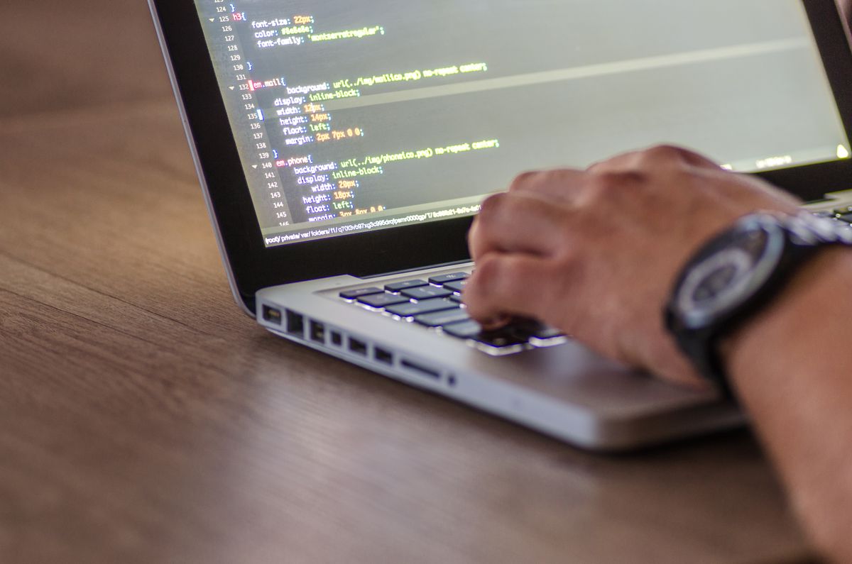 Developer's hands typing code on a laptop