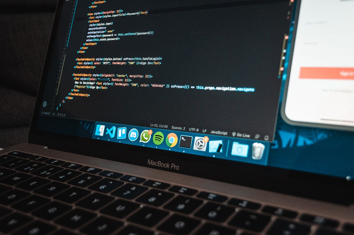 Laptop hiển thị dòng code lập trình trên bàn làm việc
