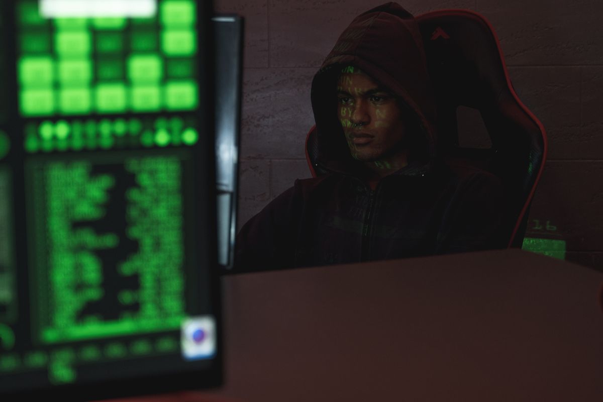 Hacker đội mũ trùm trước màn hình máy tính