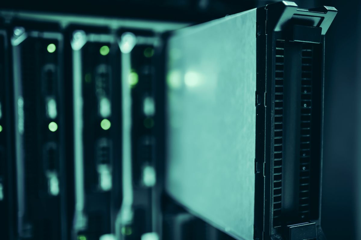 Cận cảnh các phiến máy chủ blade cắm trong khung rack, đèn báo xanh lá nhấp nháy, ám màu xanh ngọc