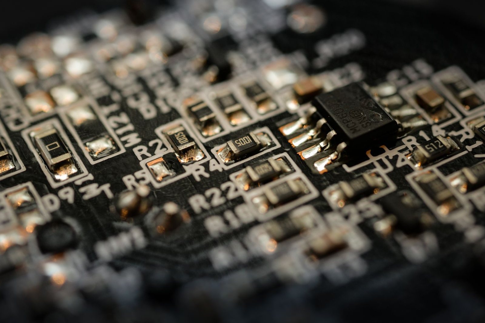 Close-up of a microchip and components on a black circuit board — illustrating AI hardware